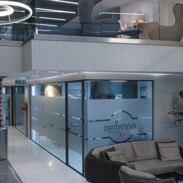 Modern dental clinic with glass-walled rooms and a stylish waiting area.